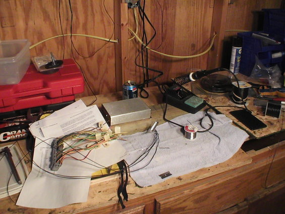 Workbench with soldering iron, wires, circuit boards, and tools