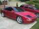 1995 Ford Probe - A red 1995 Ford Probe coupe is parked next to a red SUV.