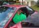 1995 Ford Probe - A man sits in the driver's seat of a red 1995 Ford Probe, with another vehicle visible in the background.