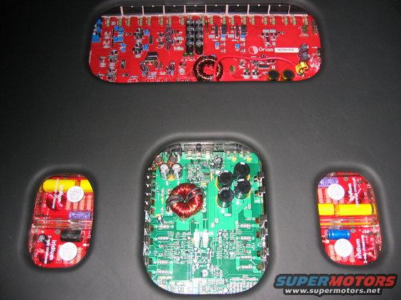 img_0783.jpg Heart of the system: DLS Amp, Orion amp, and DLS component crossovers (both opened). They are under plexiglass windows under black vinyl-wrapped false trunk floor. Not seen is squirrel fan keeping amps from overheating.