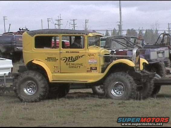 Yellow sedan with Miller Genuine Draft livery and large off-road tires