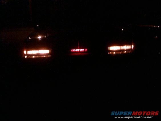 three cars' taillights illuminated at night
