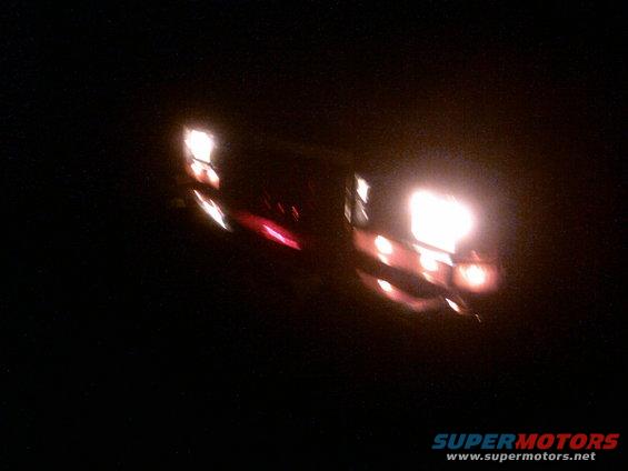 Vehicle lights at night, showing bright headlights and red taillights