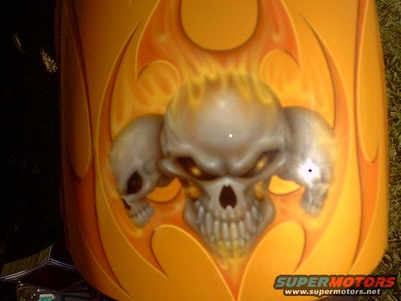 Orange motorcycle fender with airbrushed skulls and flames