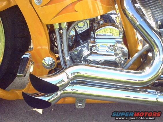 Yellow motorcycle with chrome exhaust pipes and engine details. Flames painted on the bodywork