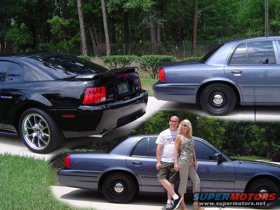 Black Mustang GT and a blue sedan with a couple posing by it