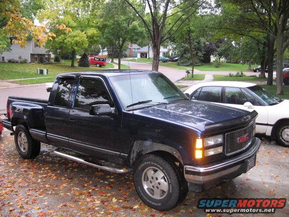 1995 GMC Sierra 1500 pickup truck parked on a driveway with fallen leaves