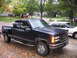 1995 GMC Sierra 1500 - A 1995 GMC Sierra 1500 pickup truck is parked on a wet driveway with a white sedan behind it.