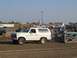 1994 Ford F-150 - A white Ford Bronco participates in a truck pull event, with spectators and other vehicles present.