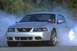 2003 Ford Mustang - Silver 2003 Ford Mustang performing a burnout with smoke surrounding the vehicle.
