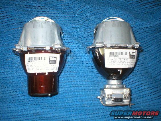 Two Valeo headlight projector assemblies with labels showing part numbers and dates