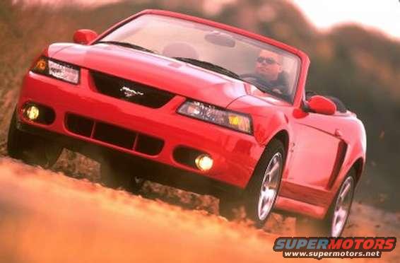 Red 2003 Ford Mustang convertible driving on dirt road