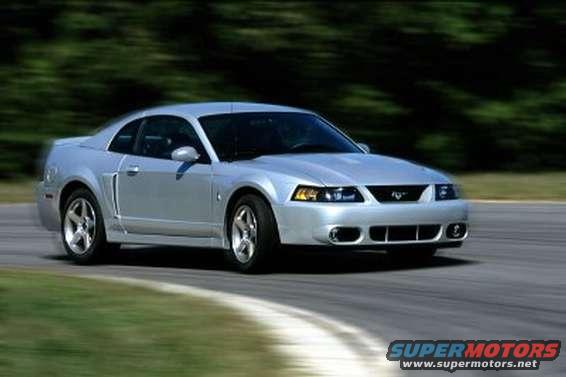Silver 2003 Ford Mustang coupe driving on a road, front 3/4 view