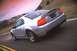 2003 Ford Mustang - Rear view of a silver 2003 Ford Mustang SVT driving on a road.