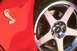 2003 Ford Mustang - Close-up of a red car's fender with a Cobra emblem and a chrome SVT wheel with Cobra brake calipers.