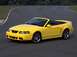 2003 Ford Mustang - A yellow 2003 Ford Mustang convertible is shown on a race track, highlighting its sporty design.