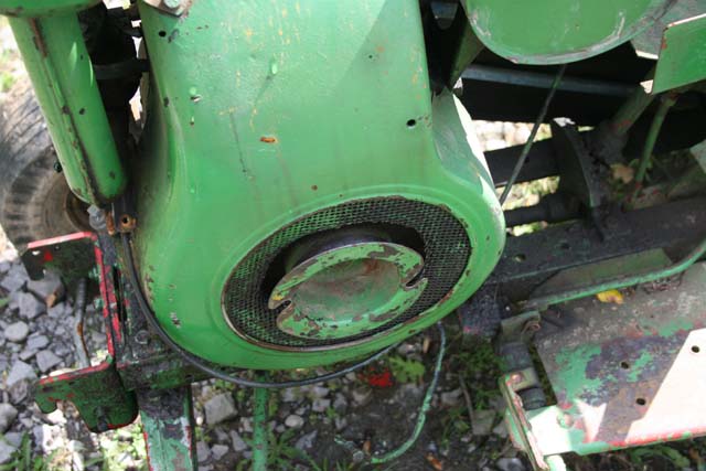 Close-up of a green tractor engine with a mesh grille