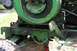 1987 Ford Bronco - Close-up of a green tractor's engine and chassis, showing mechanical components and a tire, covered in mud and rust.
