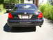 2003 Mercury Marauder - Rear view of a 2003 Mercury Marauder parked on a driveway, with a black pickup truck behind it.