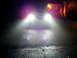 2003 Mercury Marauder - Car headlights shine brightly on a dark road at night, with a house visible in the background.