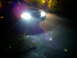 2003 Mercury Marauder - The front of a dark sedan is visible at night, with its bright headlights shining forward.