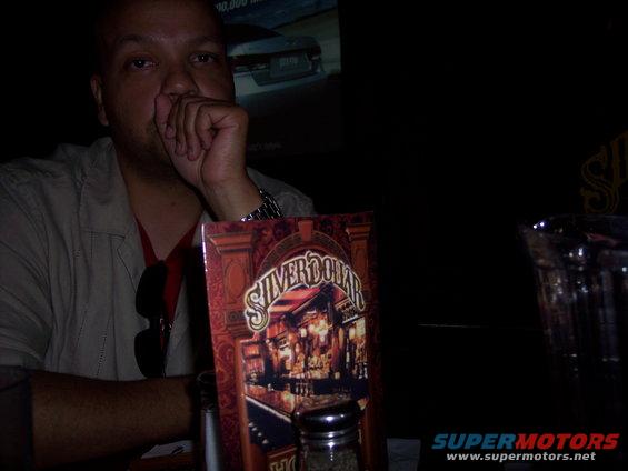 Man sitting at a table with a menu that says Silver Dollar Bar