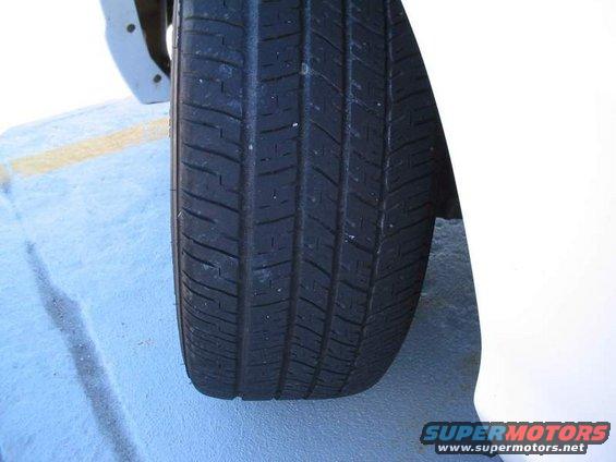 Close-up of a car tire and part of the white fender