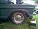 2002 Ford Crown Victoria - A Mercury hubcap is visible on the wheel of a dark-colored vehicle that appears to be undergoing some work.