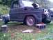 2002 Ford Crown Victoria - A dark gray Ford F-series truck body sits on concrete blocks, awaiting restoration with its front end removed.