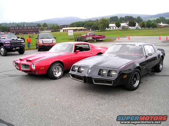 Red and black Pontiac Firebirds from the 1970s parked side-by-side