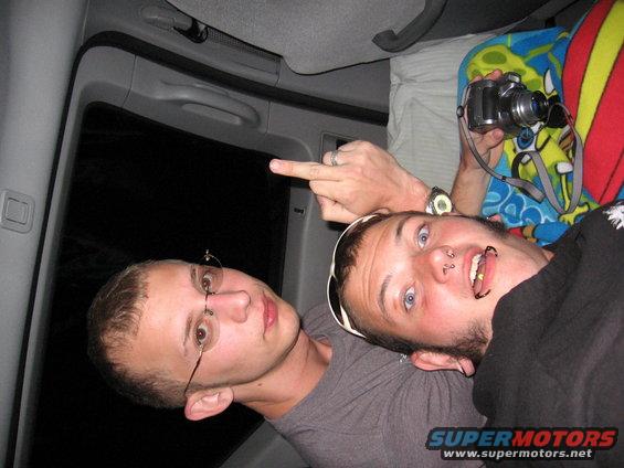 Interior of a vehicle with two men, one pointing with a middle finger
