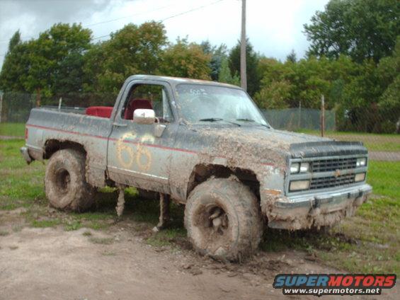Muddy pickup truck with large tires, number 66 on the side
