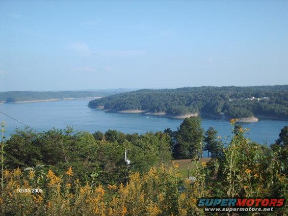 Scenic lake view with trees and a boat, dated 02/05/2005