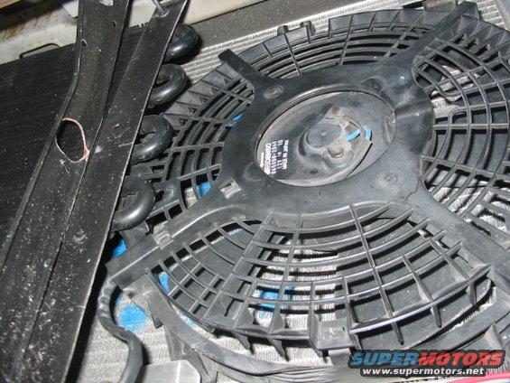 Radiator fan with visible text on the motor housing, mounted in front of a radiator