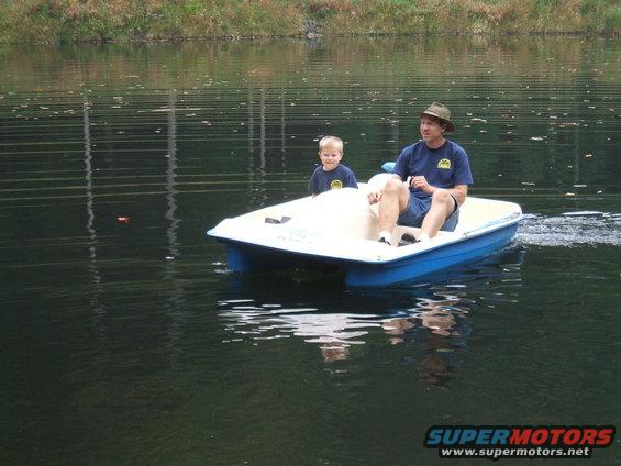 Man and boy on a pedal boat on a lake
