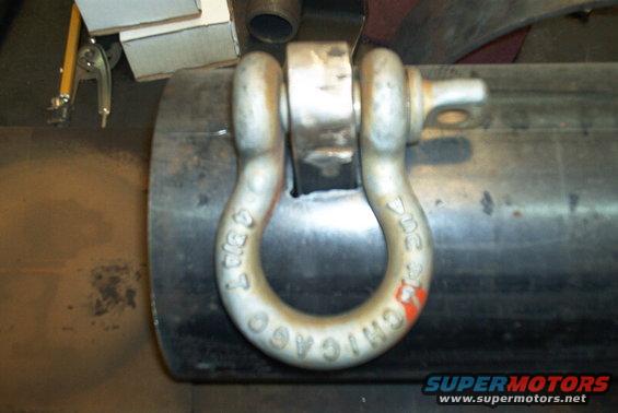 Shackle with 'CHICAGO' and '3/4 T' stamped on it, attached to a large metal pipe