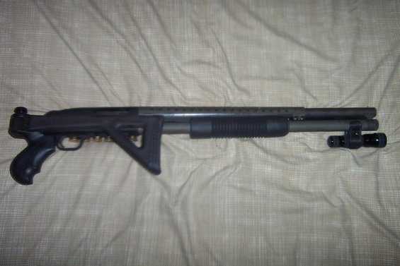 Tactical shotgun with pistol grip, adjustable stock, and mounted flashlight