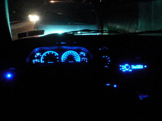 dashboard with blue gauges and radio display at night