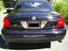 2003 Mercury Marauder - Rear view of a black 2003 Mercury Marauder, with a pickup truck visible in the background.