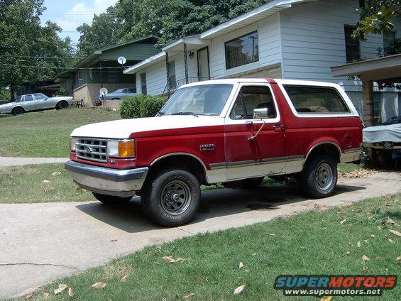 1988 Ford Bronco parked on a driveway in front of a house