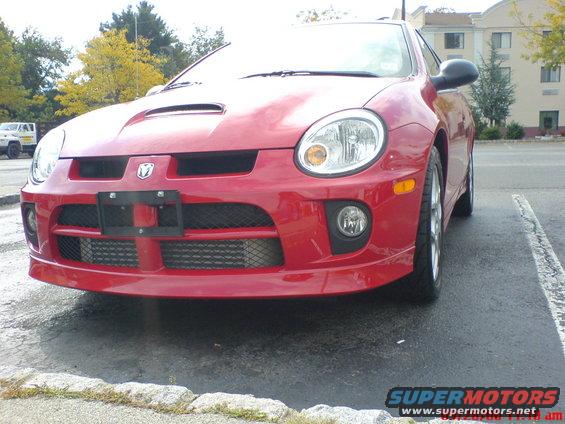 Red 2005 Dodge SRT-4 front bumper with intercooler visible, parked in a lot