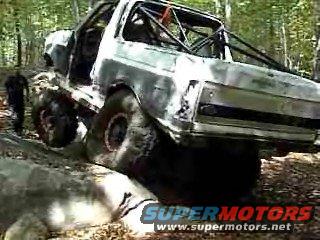 1995 Ford Bronco modified for off-roading, with large tires and a roll cage, on a rocky trail