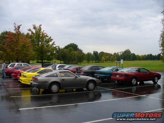 Red 1991 Ford Probe parked in a wet lot, side view