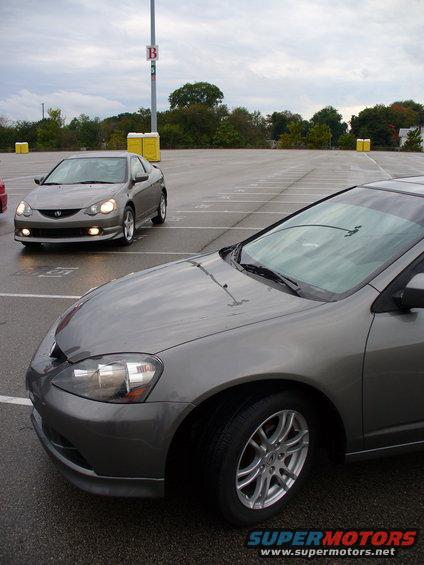 Grey coupe in foreground, another grey coupe in background, parked in lot