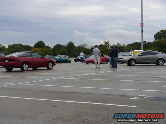 Red 1991 Ford Probe coupe, side view, parked in a lot with other cars