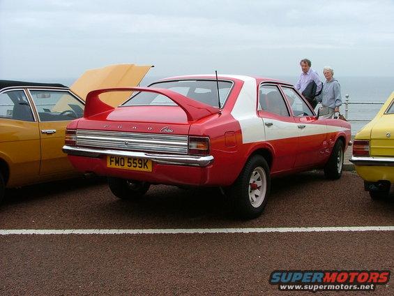 Red and white Ford Cortina with a rear spoiler and yellow license plate FMO 559K