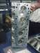 1990 Ford Mustang - A close-up of an aluminum engine cylinder head is displayed, with a young boy observing it.