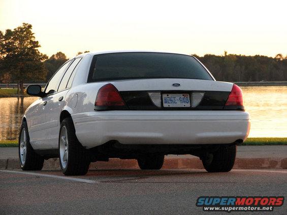 White 2003 Ford Crown Victoria rear view, parked by a lake at sunset