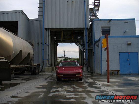 Red 1991 Ford Probe parked in front of industrial buildings