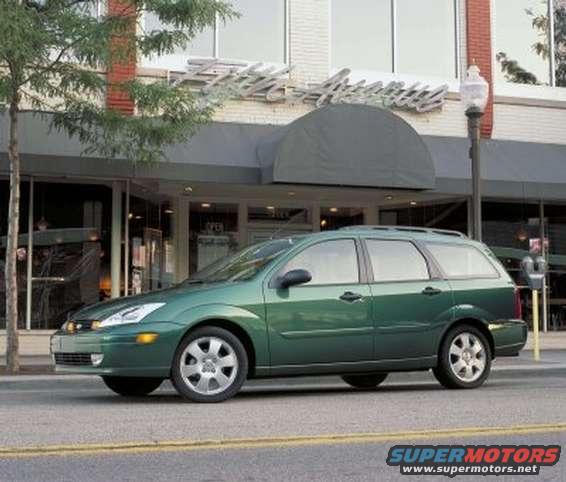 Green 2002 Ford Focus wagon parked on street in front of building